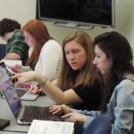Young professionals collaborating on laptops