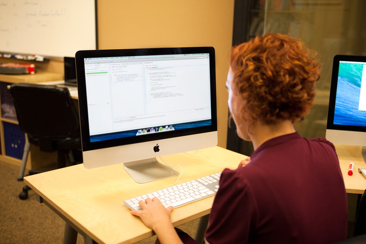 Programmer writing code on a desktop computer